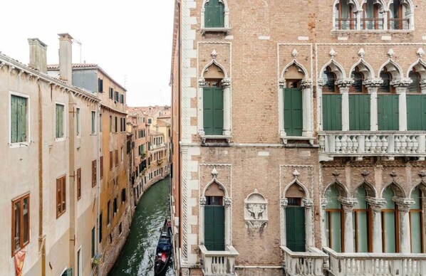 A narrow canal flanked by historic buildings with arched windows and balconies. - "LA FENICE" APARTMENT (Venezia)
