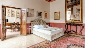 A bedroom with a large bed, a wooden desk, and a mirror. - "LA FENICE" APARTMENT (Venezia)