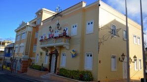 A yellow building with a balcony, decorative elements, and a star-shaped light fixture.