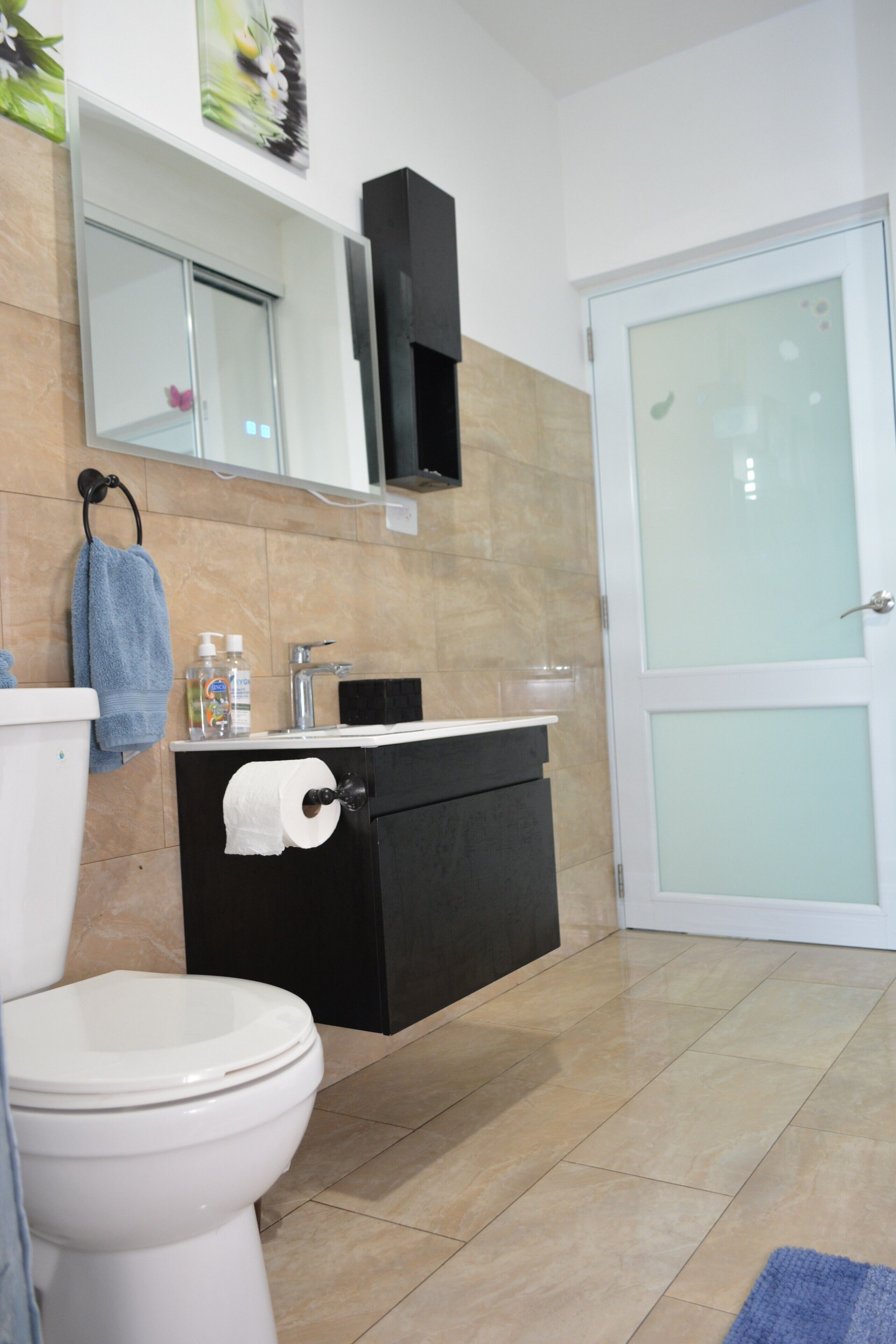 Ein modernes Badezimmer mit Toilette, Waschbecken und Spiegel.
