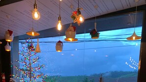 A cozy restaurant interior with a large window offering a view of a snowy landscape.