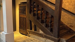 A stone staircase with wooden balusters leading to a landing.