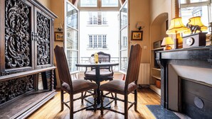 A room with a dining table and chairs, a fireplace, and a view of the outside.