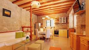 A cozy living room with a sofa, ottomans, a glass coffee table, and a dining area with chairs and a table. - All you need studio apartment in Split city center (Split)