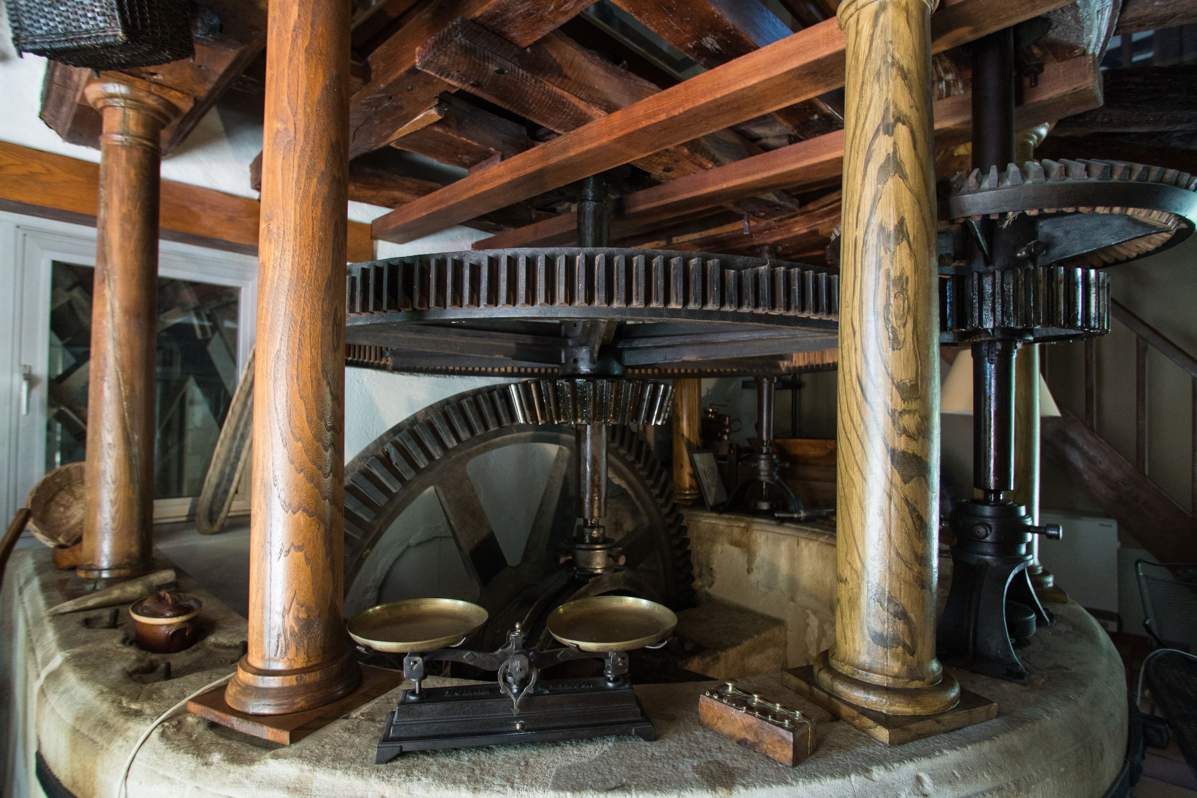 Um mecanismo com engrenagens e colunas de madeira, possivelmente uma exposição histórica.