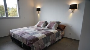 Un dormitorio con una cama, dos lámparas de pared y una ventana.