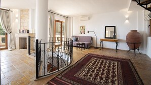 A spacious living area with a fireplace, a sofa, a coffee table, and a large rug.