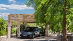 A car parked under a pergola in a garden setting. - Villa Agape - Three Bedroom Villa with Swimming Pool (Mirca)