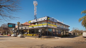 Hotel Crespo med et tydeligt skilt, et højt kommunikationstårn i baggrunden og en klar blå himmel.