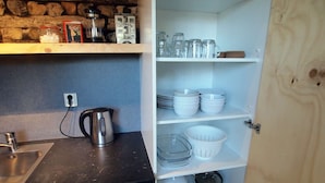 Una cocina con estufa integrada, cafetera y lavaplatos.