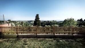A fenced outdoor area with a view of a distant landscape, including trees and a clear sky. - Casa Erika, relax in Tuscany   (Partino)