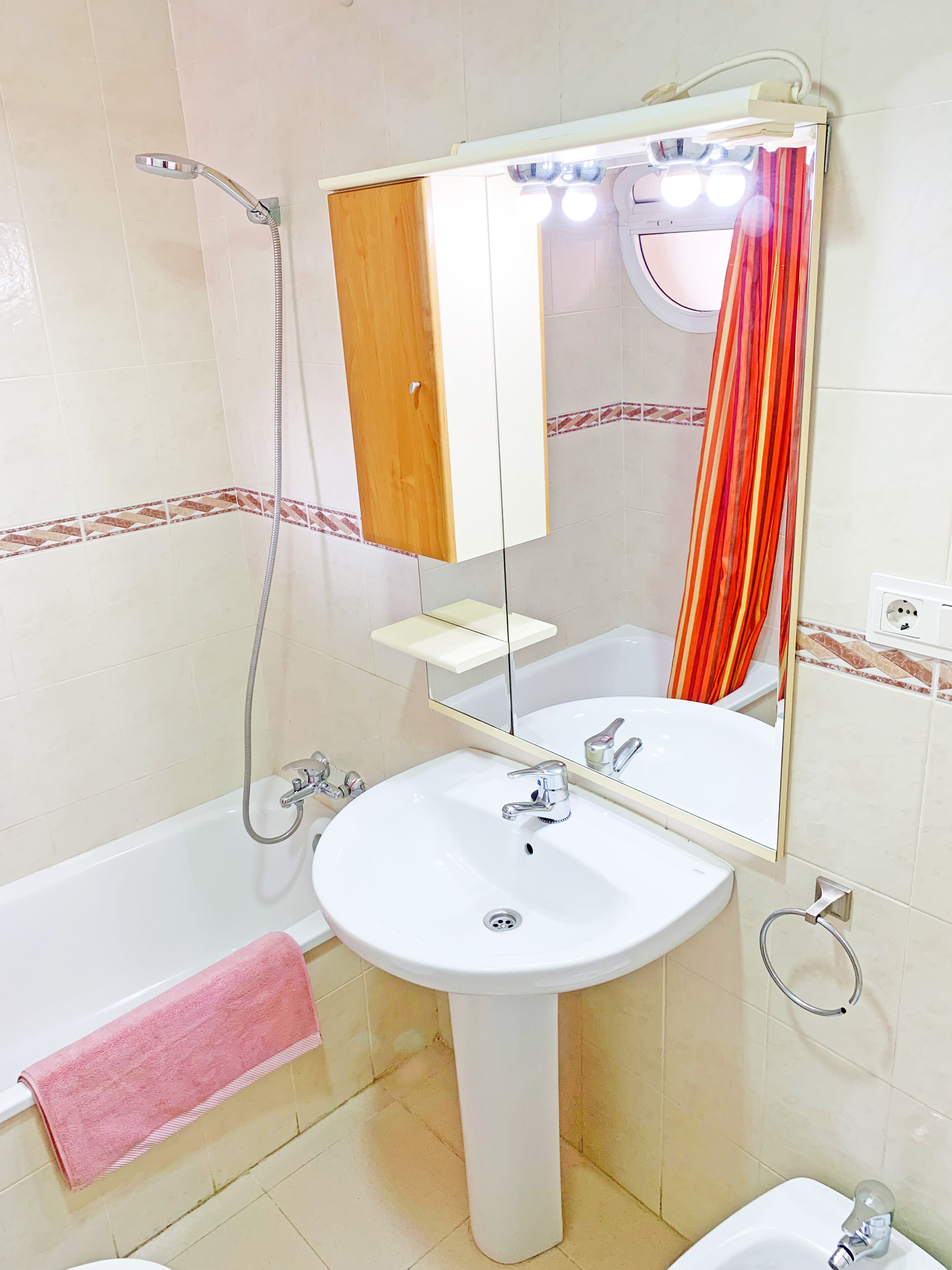 Un baño con un lavabo blanco, un espejo, una ducha y una bañera.