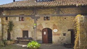 A stone building with a tiled roof, a wooden door, and a small window. - House of integral rent in the center of Cantabria. 8 people (La Serna de Iguña)