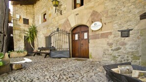 A stone building with a wooden door, a wrought iron gate, and a sign that reads "VIVIENDA". - House of integral rent in the center of Cantabria. 8 people (La Serna de Iguña)