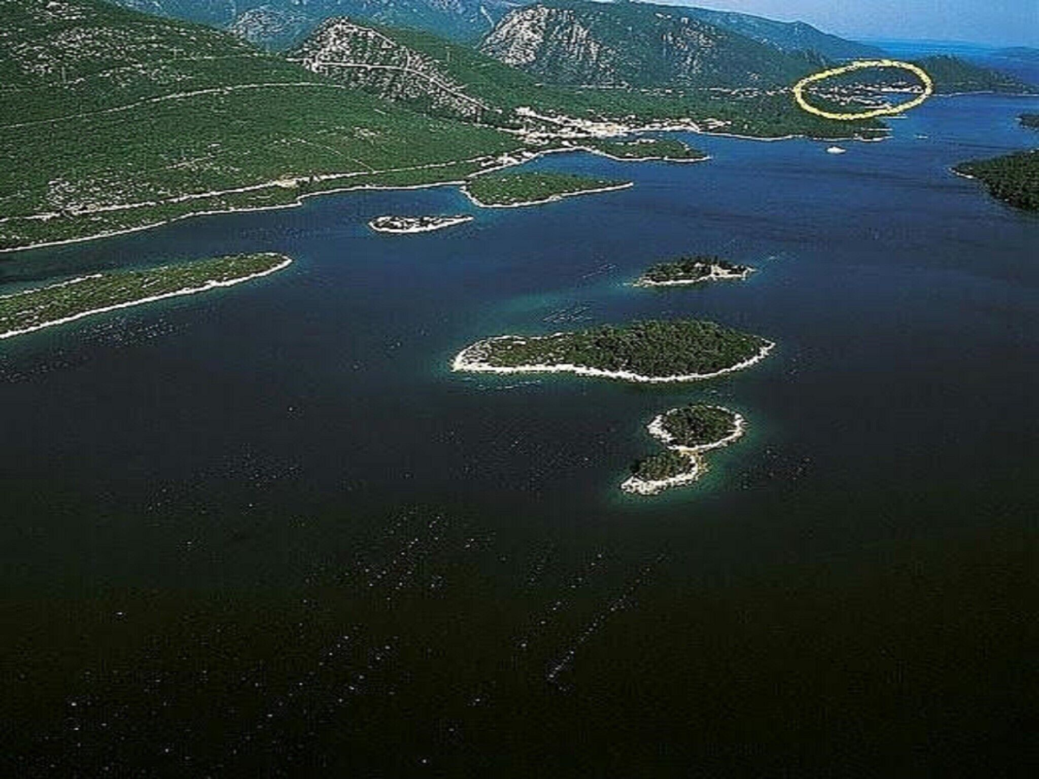 Vista aerea di una zona costiera con diverse isole e un ampio specchio d'acqua.