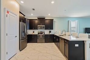 Stovetop, dishwasher, cookware/dishes/utensils - 8BR ChampionsGate Pool Home w MTheater (Davenport)