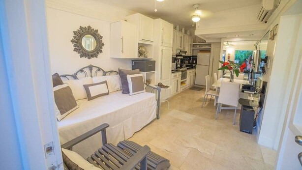 Een kleine hotelkamer met een bed, een bureau en een kitchenette.