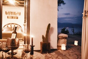 A table with wine glasses, a candle, and a bottle of wine.