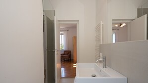 A modern bathroom with a white sink, mirror, and a wooden chair in the background. - Exclusive holiday home in Sveta Marina, Istria, Croatia - right by the sea (Sveta Marina)