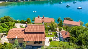 A coastal property with multiple buildings, each featuring a red-tiled roof and surrounded by lush greenery. - Exclusive holiday home in Sveta Marina, Istria, Croatia - right by the sea (Sveta Marina)