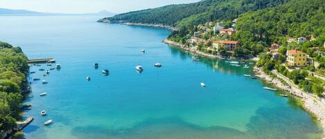 A coastal town with a clear view of the sea, boats, and buildings along the shore.