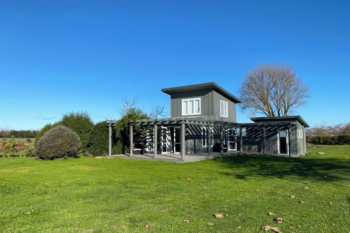 A modern two-story house with a covered patio area.