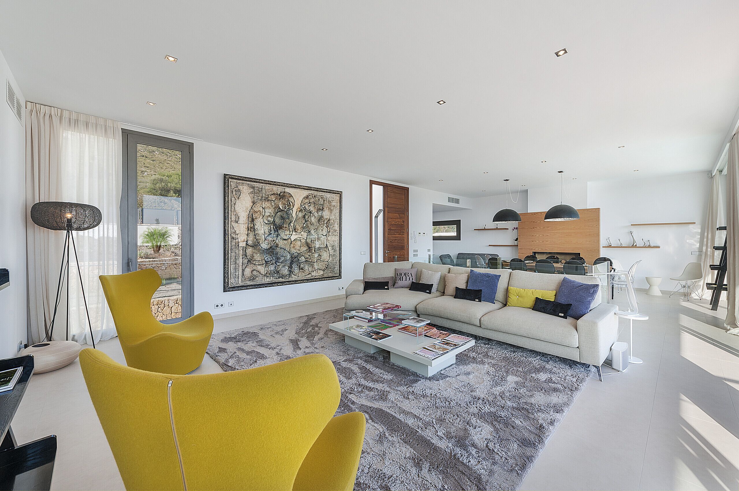 A modern living room with a sofa, coffee table, and yellow chairs.