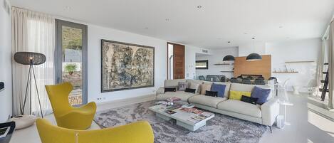 A modern living room with a sofa, coffee table, and yellow chairs.