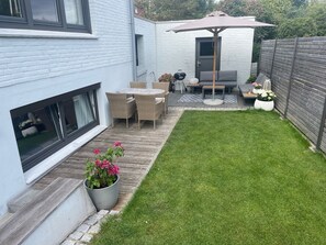 A modern patio with a dining set, a barbecue grill, and a seating area with a table and chairs. - Dock 8 beaches: Only 50 meters to the sandy beach and the promenade (Strande)