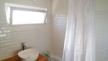 Bathtub, hair dryer, towels, shampoo
