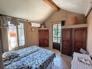 A bedroom with a bed, a wardrobe, a window, and a door.