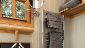 Une salle de bain avec un lavabo blanc, un miroir, un porte-serviettes et des toilettes.