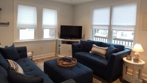 A living room with two sofas, a television, and a ceiling fan. - Newly renovated family home 11/2 blocks from the beach and town center (Sea Isle City)