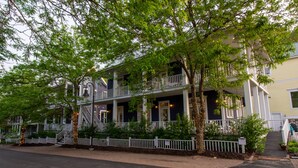 A two-story building with a balcony, a covered porch, and a staircase leading to the entrance. - Luxury Beachwalk Resort House Closest to Beach includes resort amenities (Michigan City)