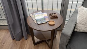 Ein kleiner runder Holztisch mit einer Zeitschrift, einer Holzschale und einer Schüssel.