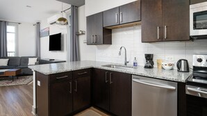 Eine moderne Küche mit dunklen Schränken, einer Granit-Arbeitsplatte und Edelstahlgeräten.