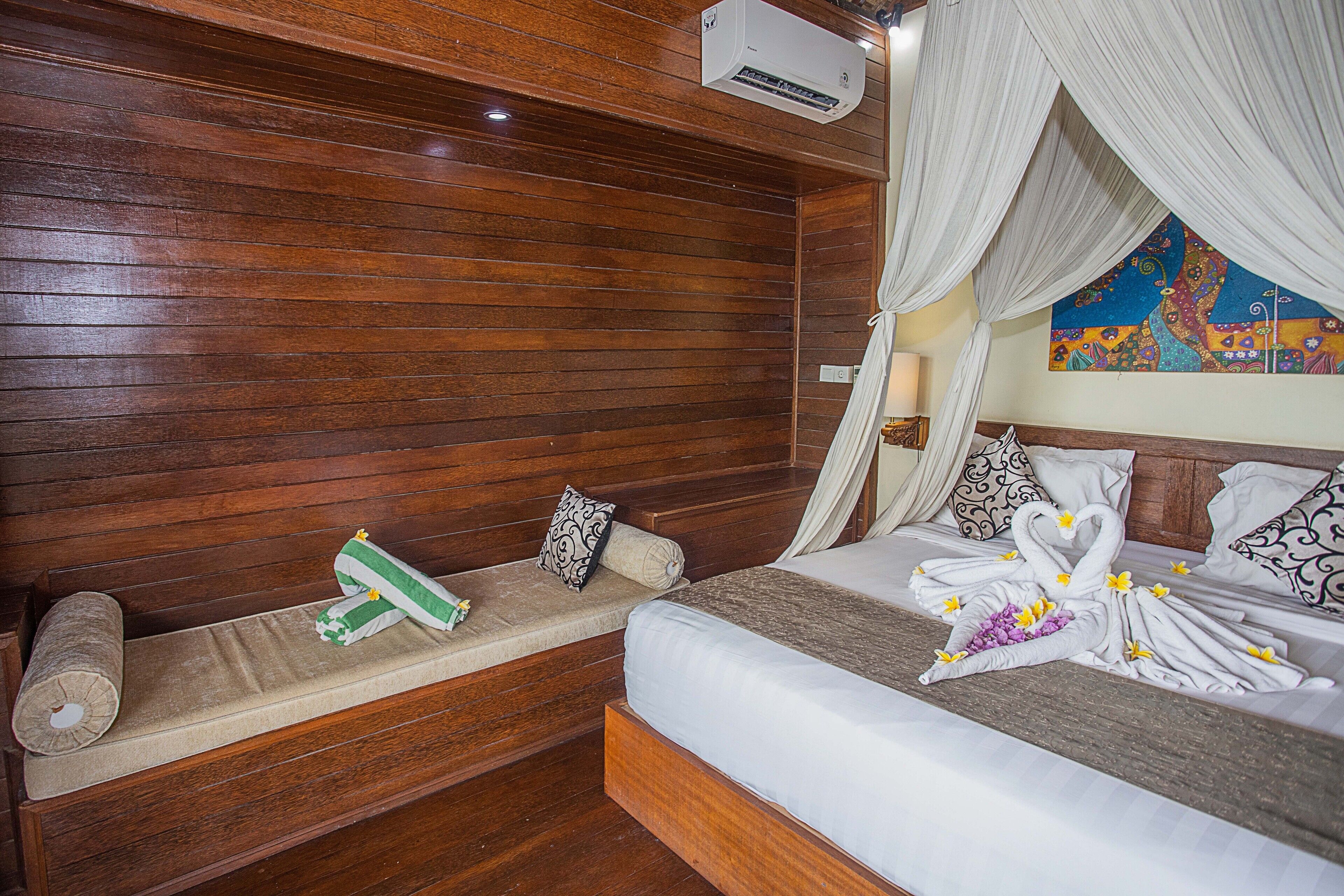 A wooden-paneled room with a bed, a bench, and a mural on the wall.