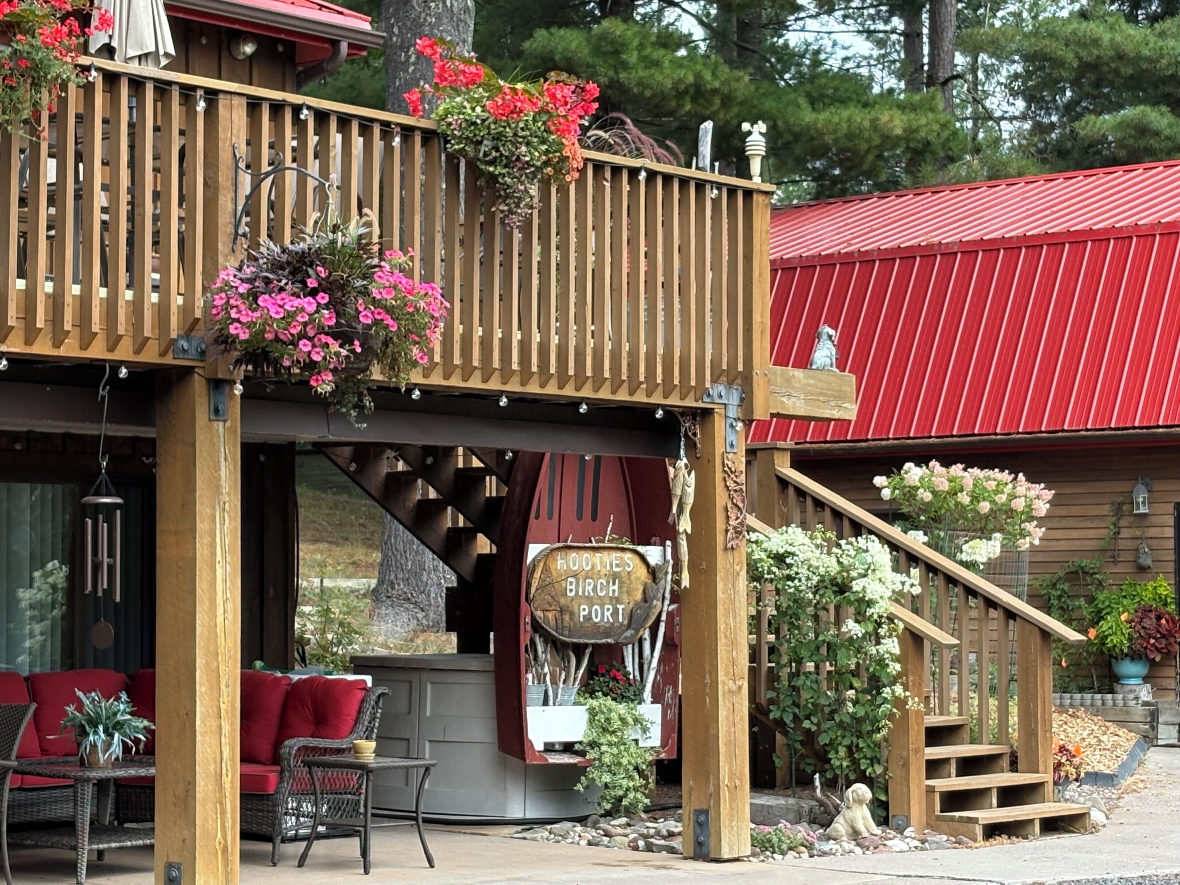 A wooden building with a red roof, a sign reading 'HOYT'S RIBCH POT', and a balcony with hanging flower baskets.