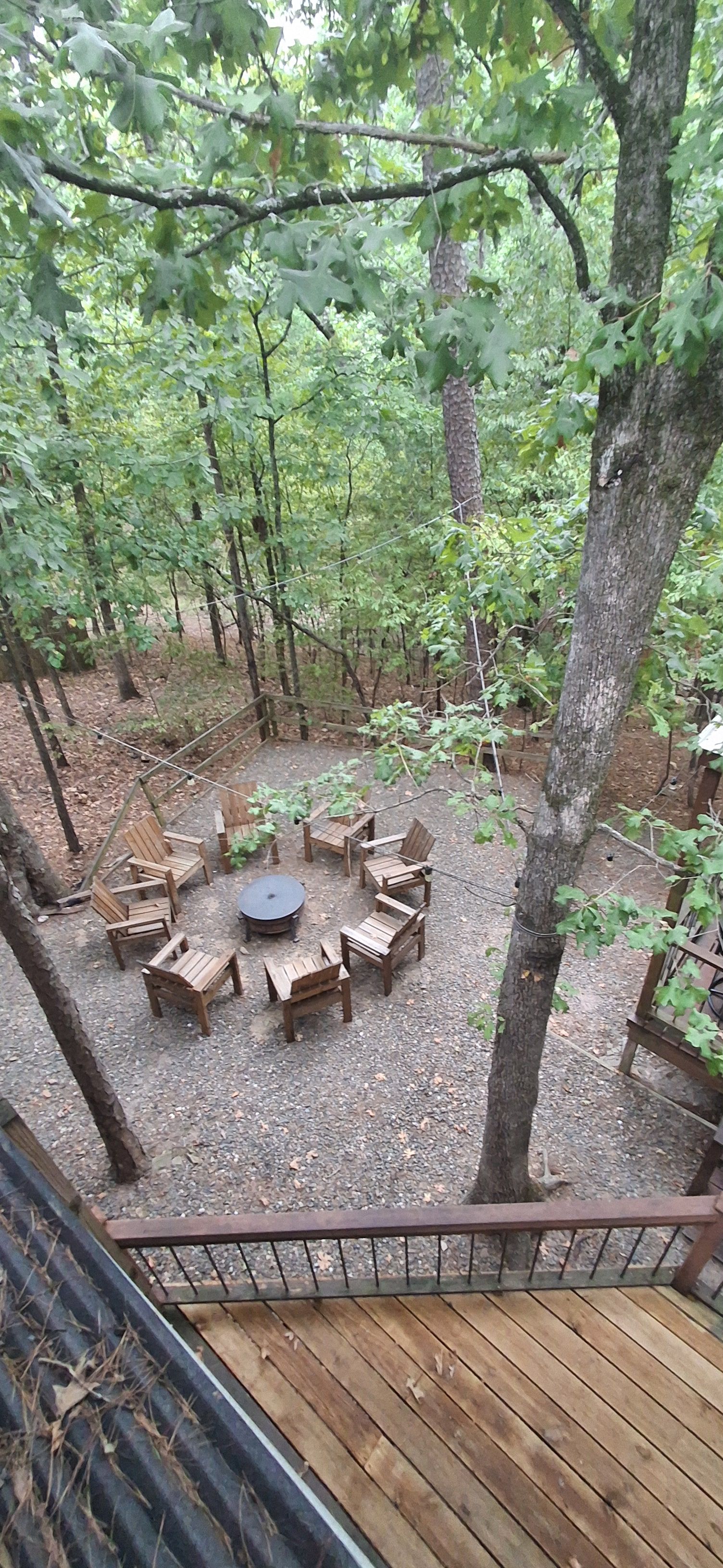 Eine Terrasse mit Holzmöbeln, die für das Essen im Freien bereitstehen, umgeben von Bäumen.