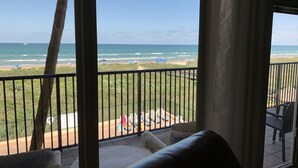 A balcony with a view of the beach, including umbrellas and beach chairs. - Beachfront, Luxurious, Great Location with Amazing Views!!! (South Padre Island)