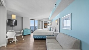 Une chambre d’hôtel moderne équipée d’un lit, d’un canapé, d’un bureau et d’une télévision.