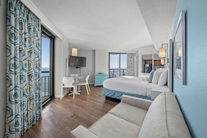 Une chambre d’hôtel avec un lit, un bureau, une chaise, une télévision et un balcon avec vue.