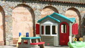 A children's play area with a small house, a table, chairs, and a toy crocodile. - Appartamento 108 Benaco (Tignale)