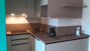 A modern kitchen with a built-in stove, a sink, and a coffee maker. - Appartamento 108 Benaco (Tignale)