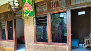 A room with large windows, a tiled floor, and a bed with a blue cover. - Ojeks Homestay (Ubud)