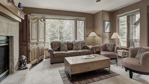 A living room with a fireplace, a sofa set, a coffee table, and a ceiling fan. - 2br- Arrowhead Village- Great Location And Gorgeous  2 Bedroom Condo by RedAwning (Edwards)
