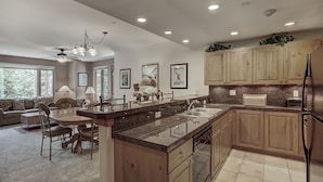 A modern kitchen with wooden cabinets, granite countertops, and a central island. - 2br- Arrowhead Village- Great Location And Gorgeous  2 Bedroom Condo by RedAwning (Edwards)
