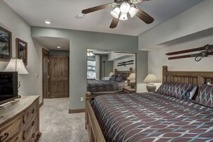 Un dormitorio con cama, cómoda, espejo y ventilador de techo.