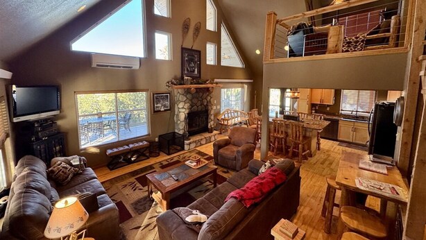 A spacious living area with a fireplace, a television, and a dining area with wooden furniture.