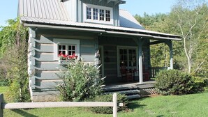 A rustic log cabin with a porch, a small deck, and a covered entryway. - Blue Ridge Mountain 'Solitude' on The Little River (Sparta)